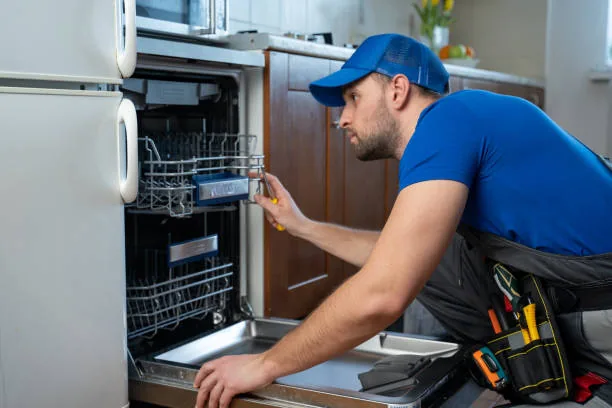 Appliance technician inspecting an open residential dishwasher