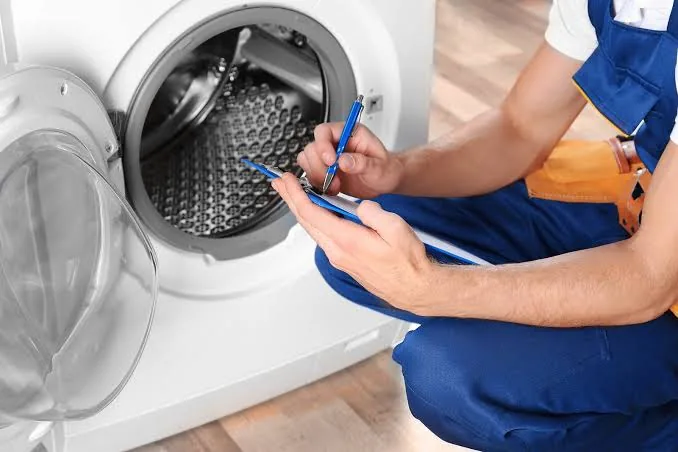 Technician documenting a washing machine service request