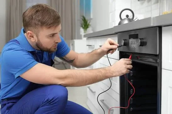 Technician using test leads to diagnose a built-in oven