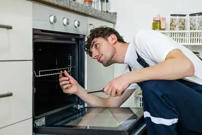 Technician inspecting the interior of a residential oven
