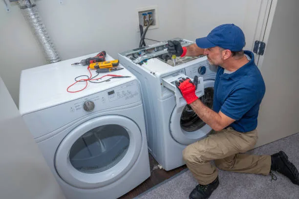 Technician diagnosing a washing machine beside a dryer